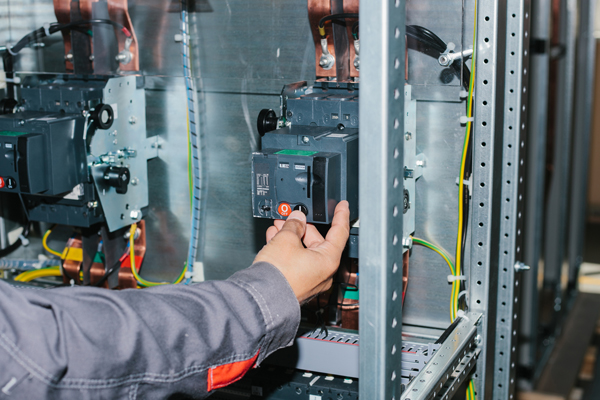 Electrician near the low-voltage cabinet. Uninterrupted power supply. Electricity.