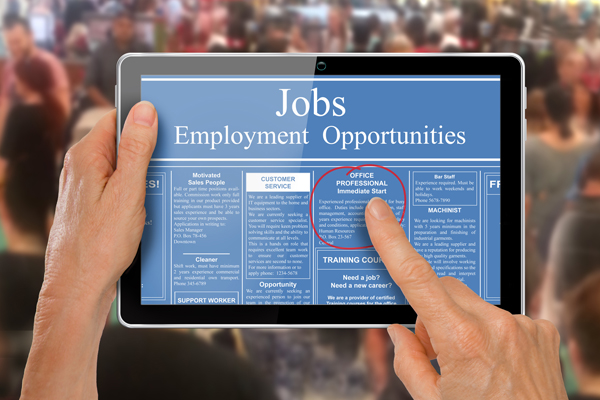 Reading online job ads on a computer tablet -